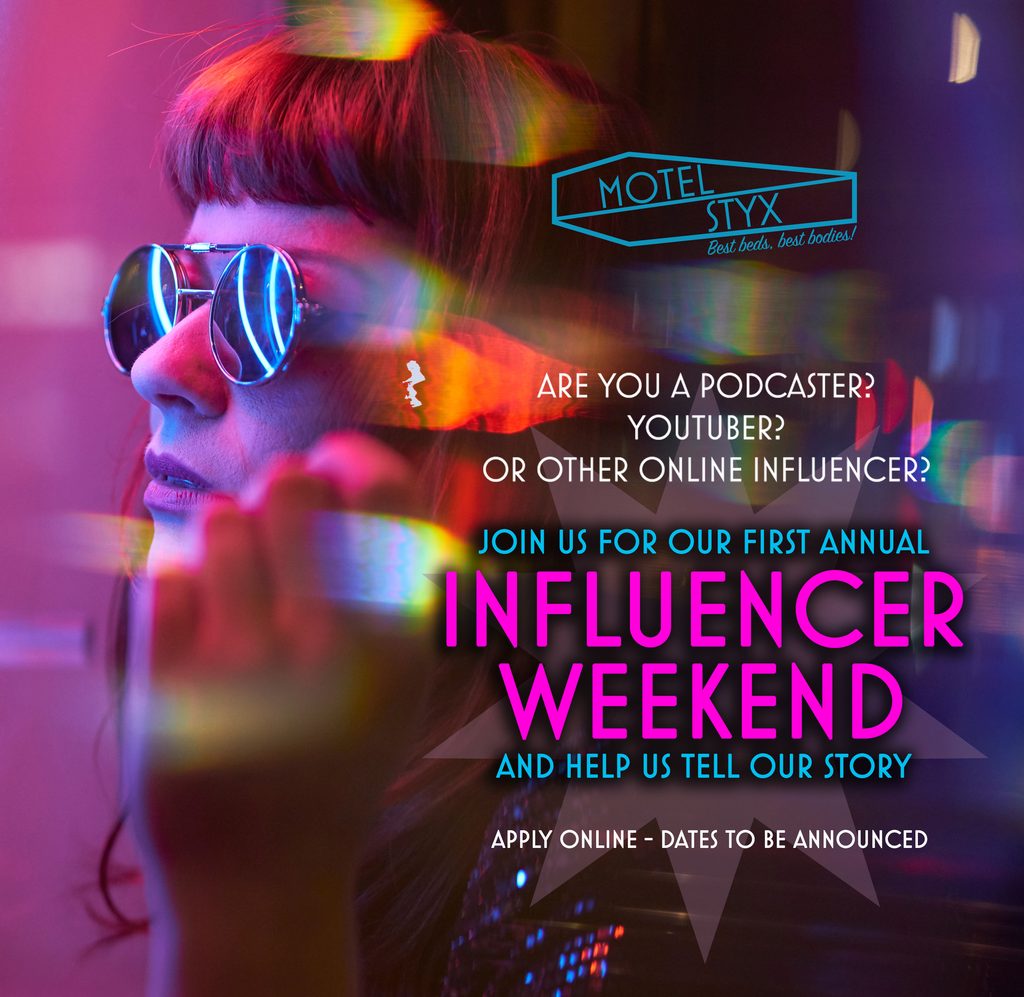 Redhead woman with dark glasses looking into a window which has a neon lit sign. Image advertises Influencer Weekend at Motel Styx